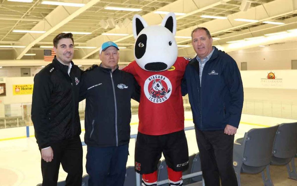 Port Colborne Mayor Bill Steele (far right) welcomes Niagara IceDogs mascot Bones to Port Colborne. 