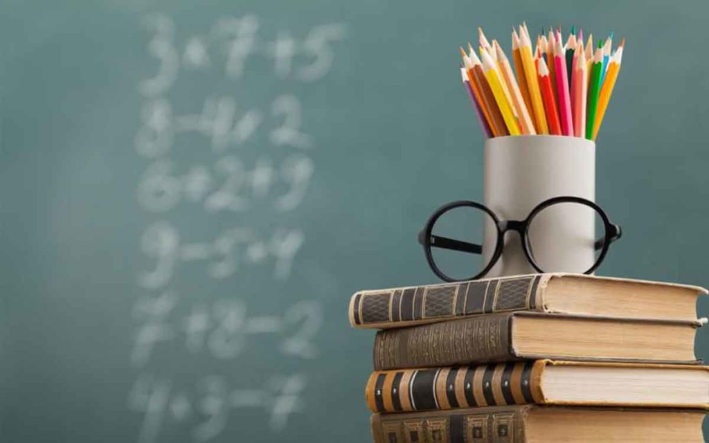 books and a pencil holder on a desk