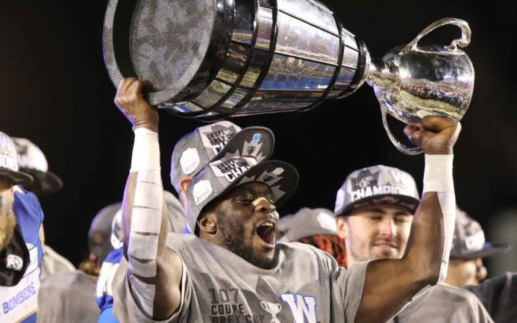 Johnny Augustine hoists the Grey Cup