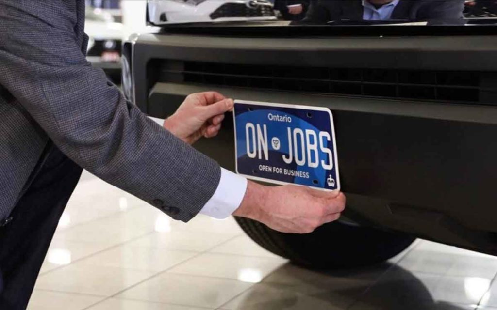 new Ontario license plate being placed on a car bumper