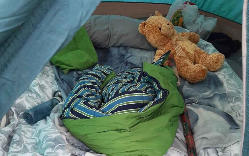 sleeping bag and teddy bear inside of a tent