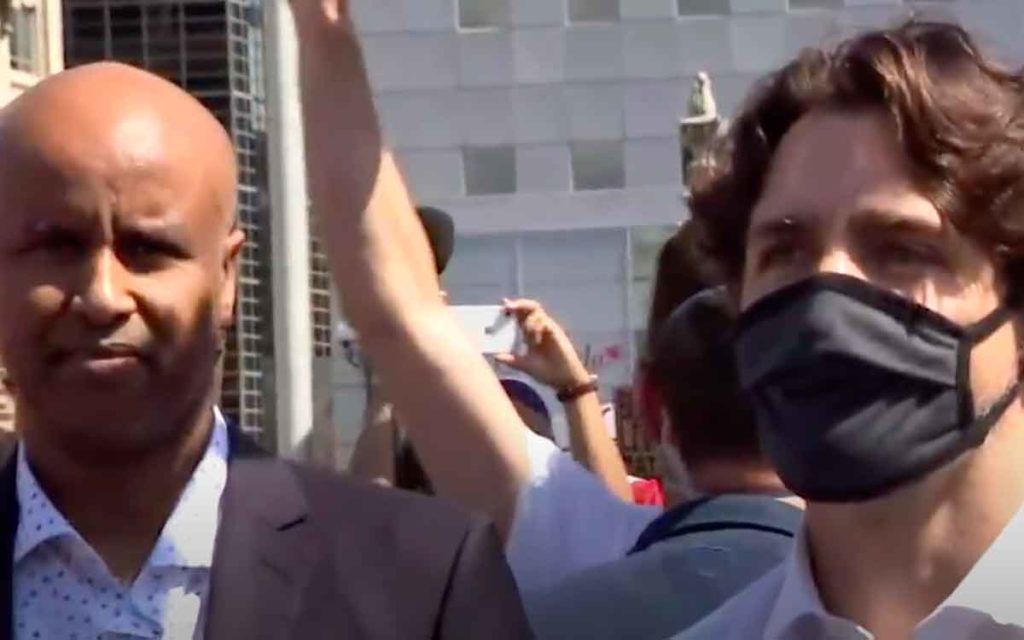 Liberal cabinet minister Ahmed Hussen stands amid thousands of fellow rally  without a mask on