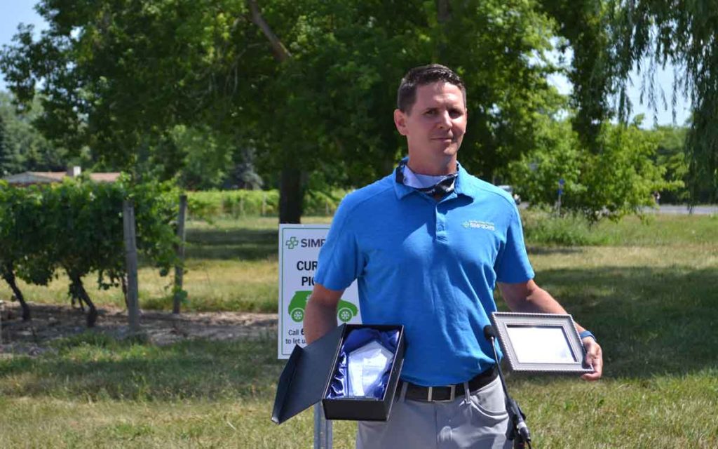 Sean Simpson holding an award