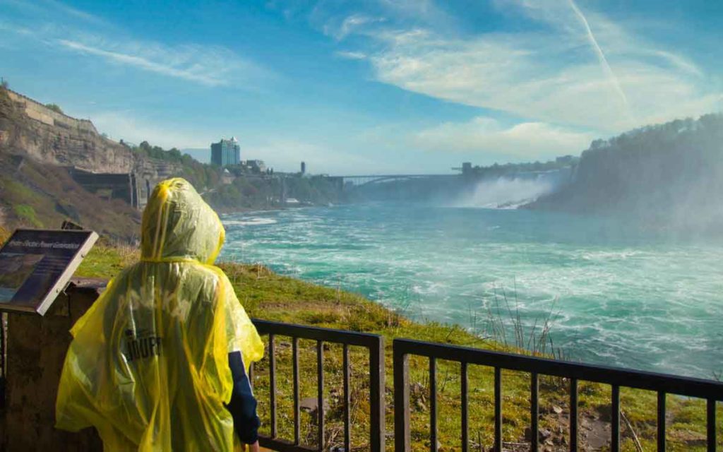 a tourist standing at the falls 