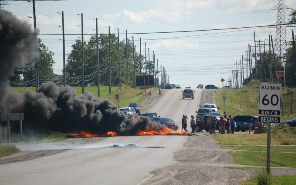 protestors at a housing development set tires on fire.