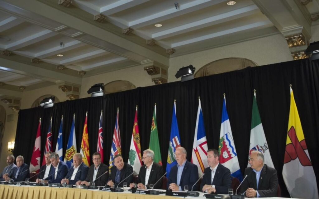 the premiers of canada sitting at a table during a meeting