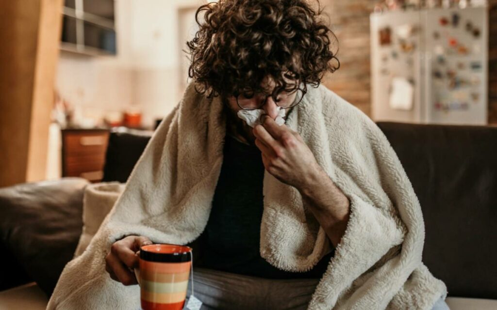 person sick sitting on their couch