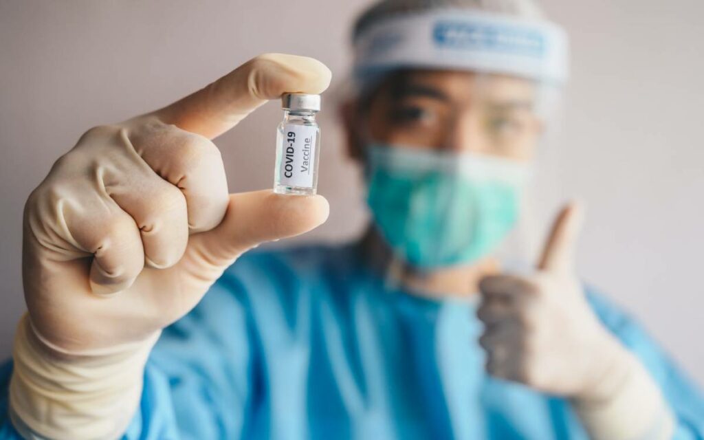 health care worker with a vaccine vial