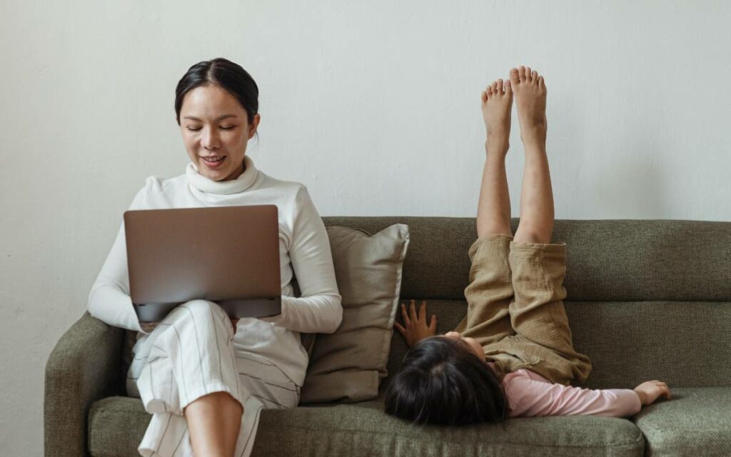 woman working on a couch with child