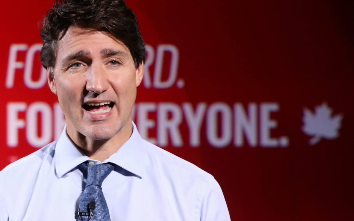 Trudeau in front of campaign slogan background