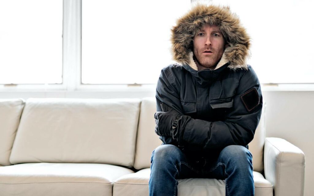 man wearing a parka on a couch 