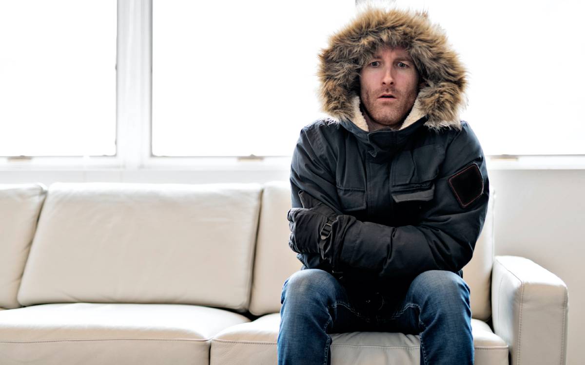 man wearing a parka on a couch
